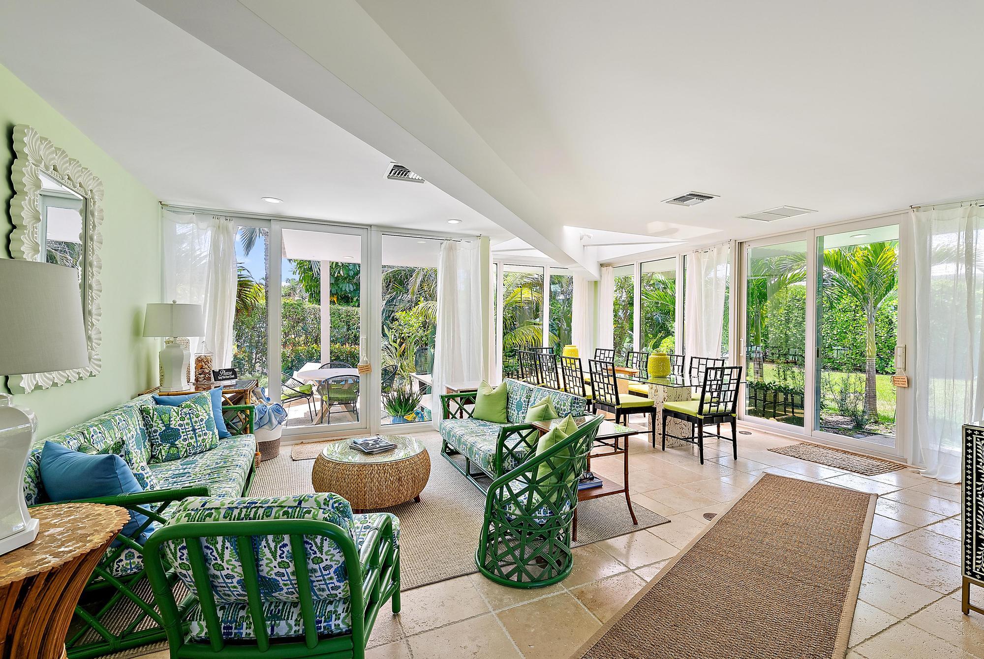 a living room with furniture and floor to ceiling windows