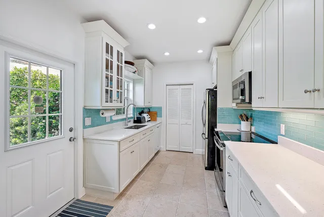 a kitchen with white cabinets and refrigerator