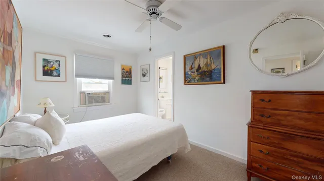 a bedroom with a bed and a flat tv screen on the dresser