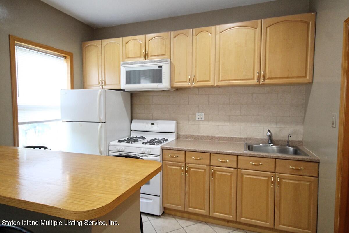 985 Lorimer Street Brooklyn, NY 11222 - Photo 13 of 23 a kitchen with stainless steel appliances granite countertop a sink a stove and white cabinets