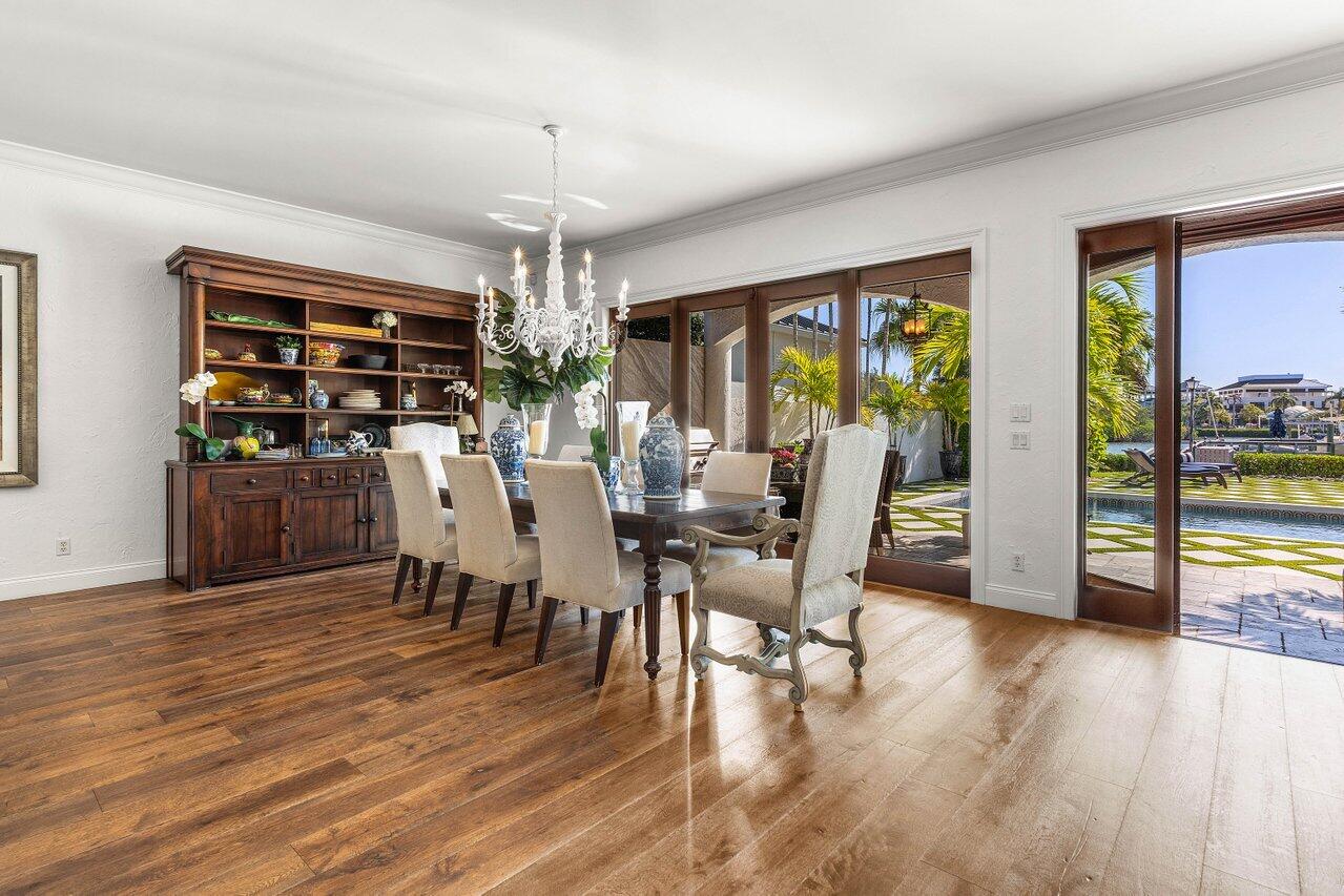 281 Fishermans Way Jupiter, FL 33477 - Photo 13 of 45 a dining room with wooden floor a chandelier a glass table and chairs