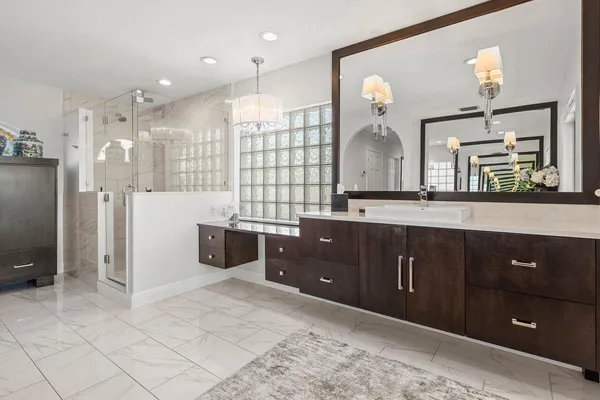a spacious bathroom with a double vanity sink a mirror and shower
