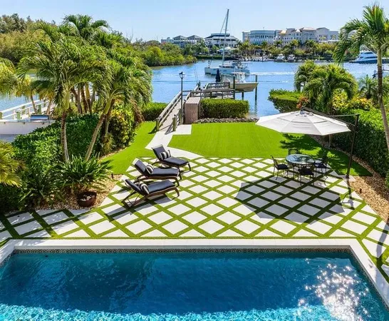 a view of a swimming pool with a yard and plants