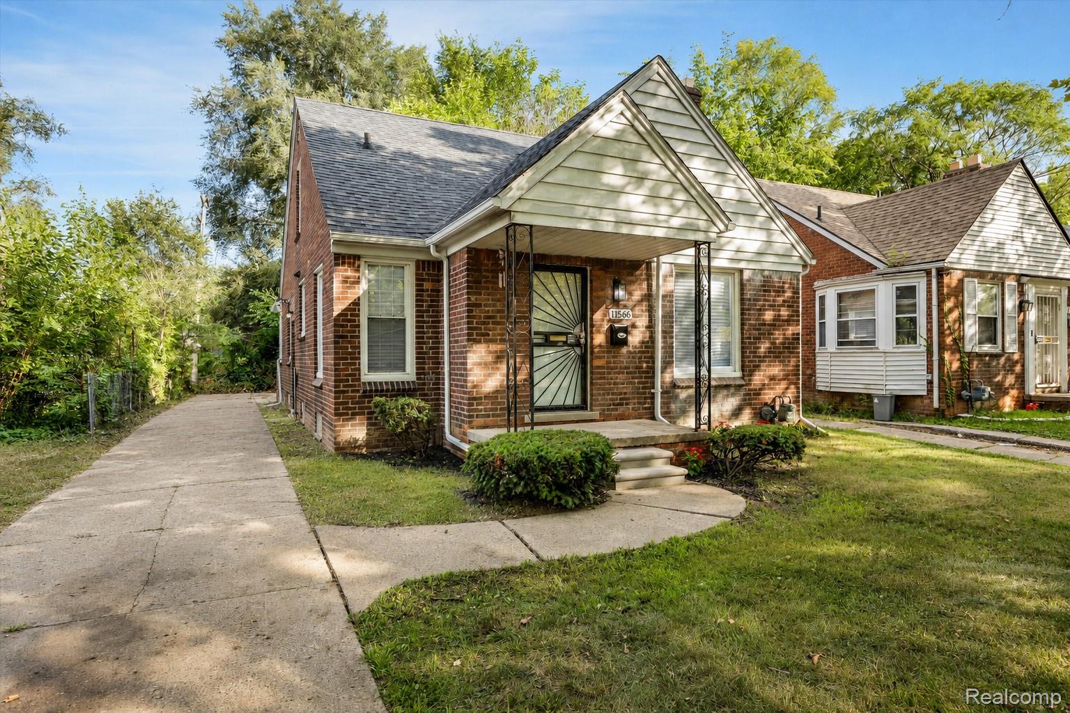 11566 Nottingham Road Detroit, MI 48224 - Photo 3 of 23 Brick exterior with white trim, covered front porch, and a concrete driveway