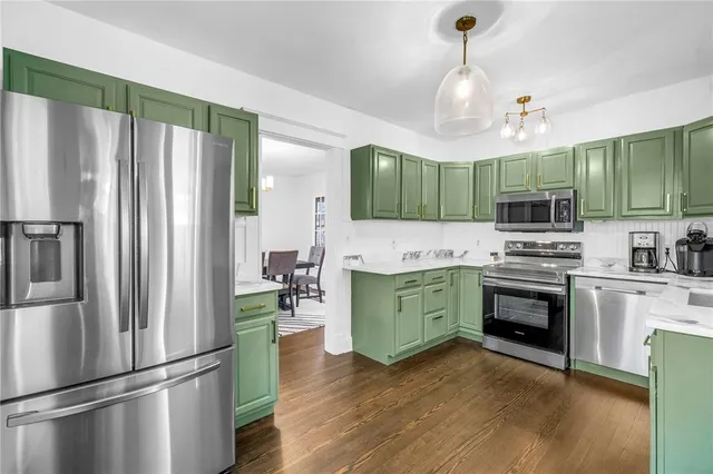 a kitchen with granite countertop stainless steel appliances and wooden floor