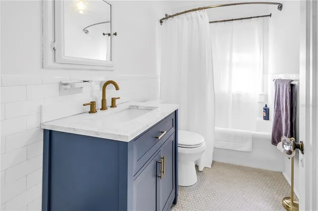 a bathroom with a double vanity sink toilet and shower