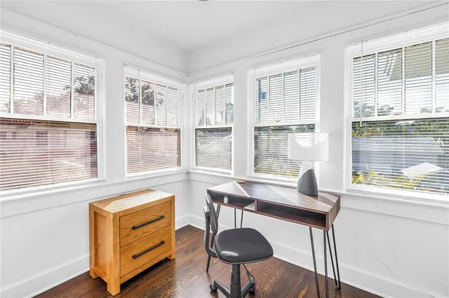 a view of a workspace with furniture and a window