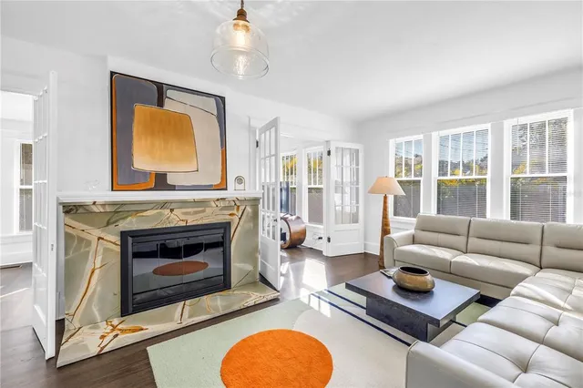 a living room with furniture a fireplace and a large window