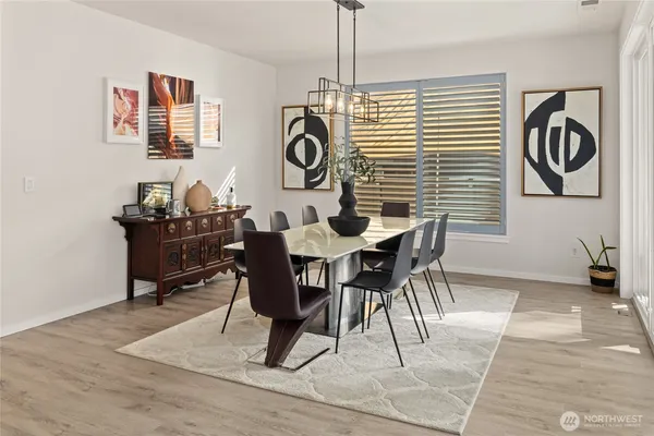 a dining room with wooden floor and a chandelier