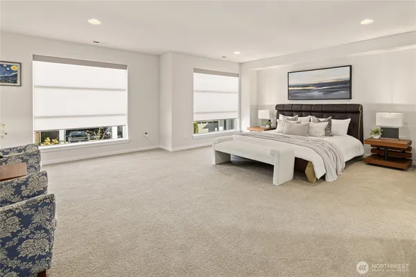 a spacious bedroom with a bed couch and a large window