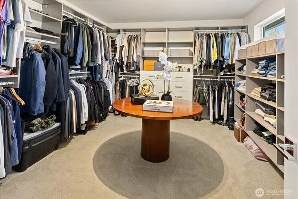 a view of walk in closet with clothes and shoes