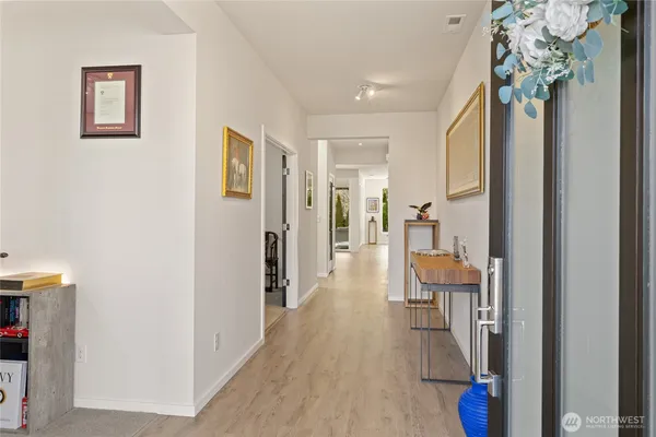 a view of a hallway with furniture and wooden floor
