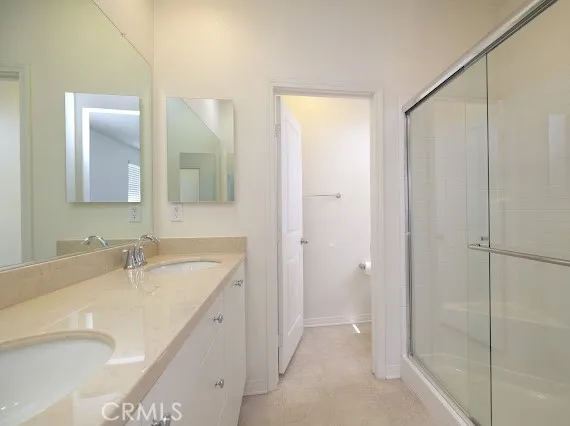 a bathroom with a granite countertop sink a mirror and a shower