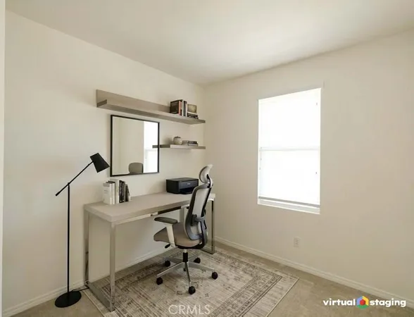 a view of a workspace with furniture and a window
