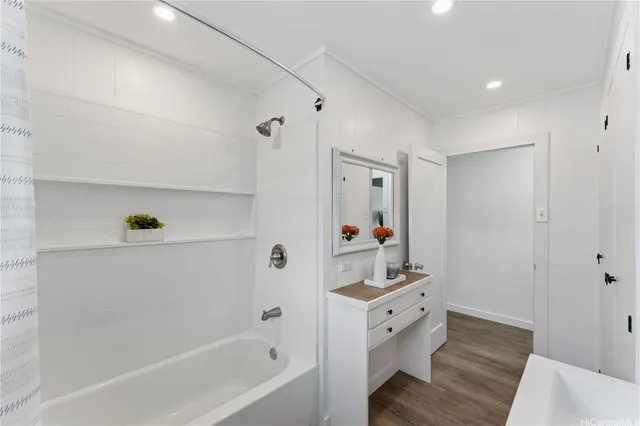 a bathroom with a bathtub sink vanity and mirror