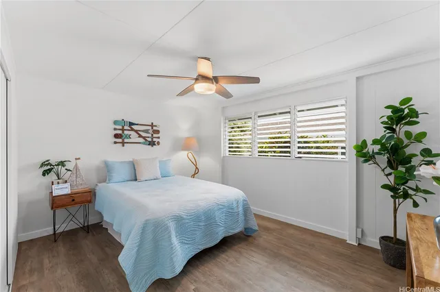 a bedroom with a large bed and a potted plant