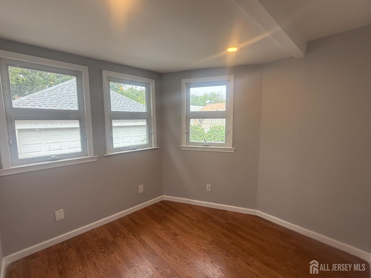 64 Fiat Avenue Iselin, NJ 08830 - Photo 24 of 25 an empty room with wooden floor and windows