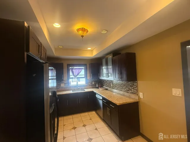 a kitchen with granite countertop a sink stove and cabinets