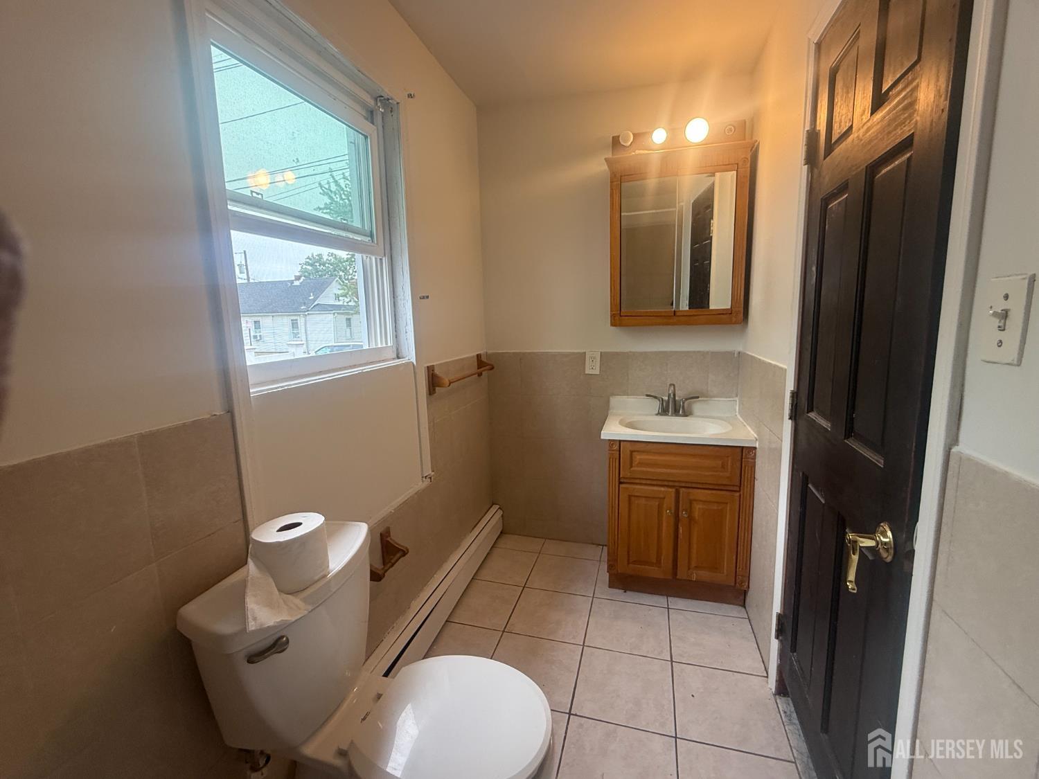 64 Fiat Avenue Iselin, NJ 08830 - Photo 7 of 25 a bathroom with a toilet sink and mirror