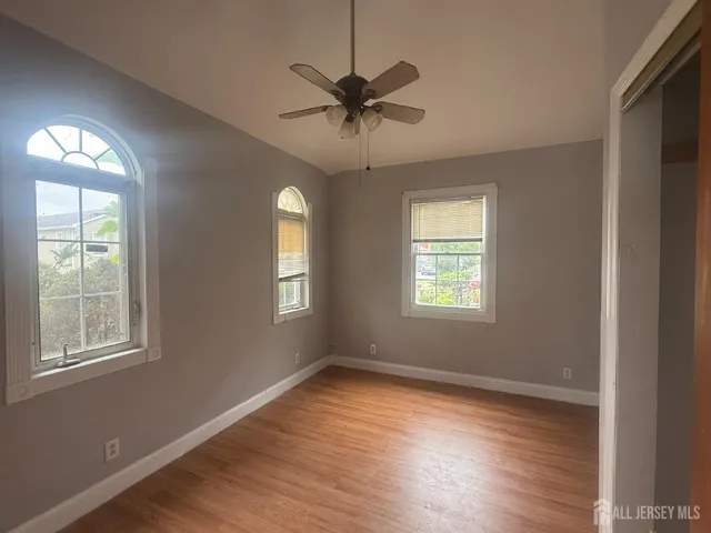 a view of a livingroom with a window and wooden floor