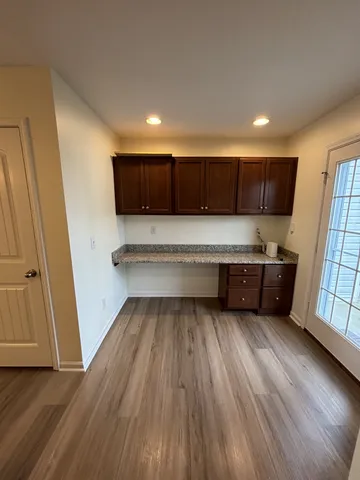 a living room with stainless steel appliances wooden floors and view kitchen