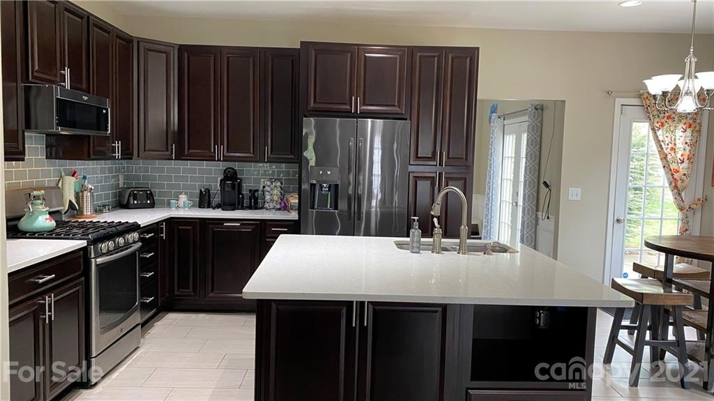 715 West Cheval Drive Fort Mill, SC 29708 - Photo 3 of 18 a kitchen with kitchen island granite countertop a refrigerator stove top oven and sink