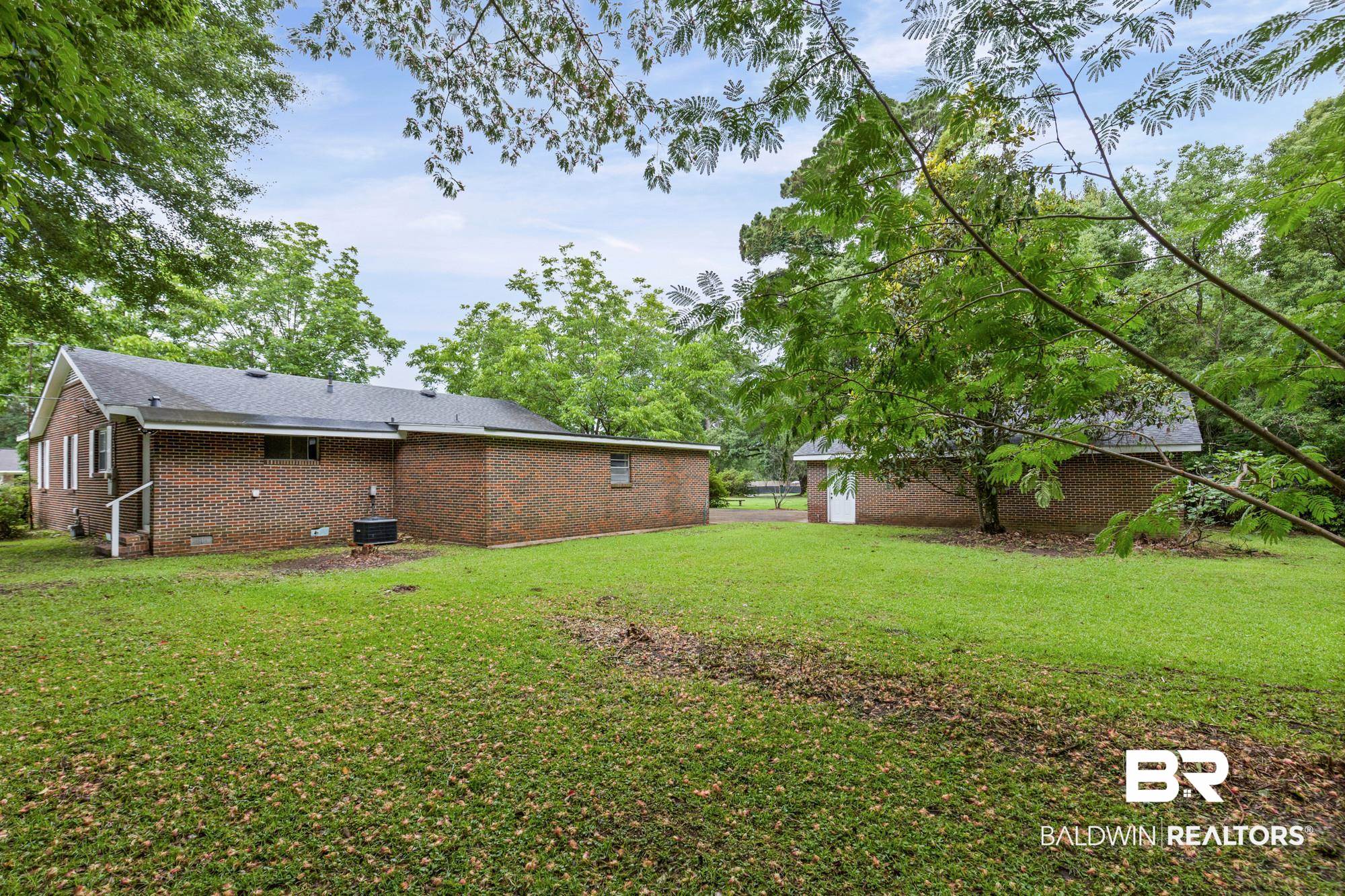312 Sutherland Drive Mobile, AL 36611 - Photo 26 of 28 Expansive green lawn with mature trees and a brick main residence