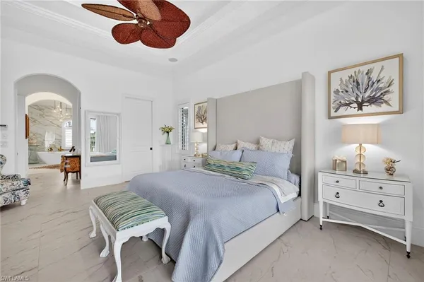 a spacious bedroom with a bed a chandelier with the wooden floor
