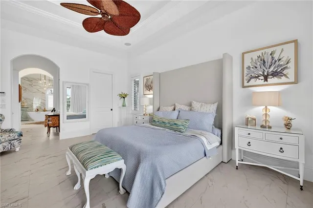 a spacious bedroom with a bed a chandelier with the wooden floor