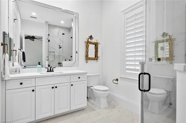 a bathroom with a double vanity sink toilet and shower