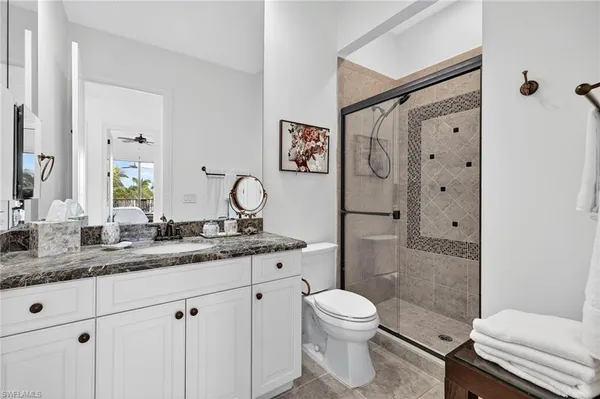a bathroom with a granite countertop sink toilet and shower