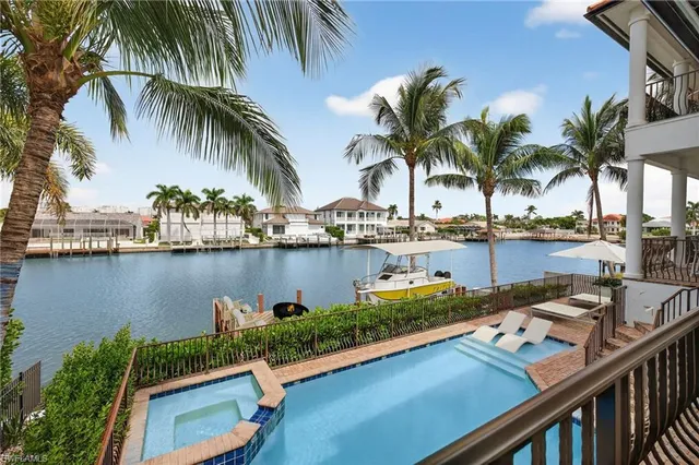 a view of swimming pool with outdoor seating and lake view
