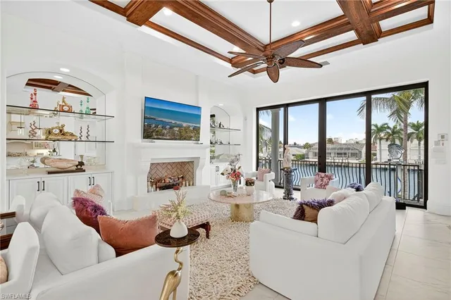 a living room with furniture fireplace and a large window
