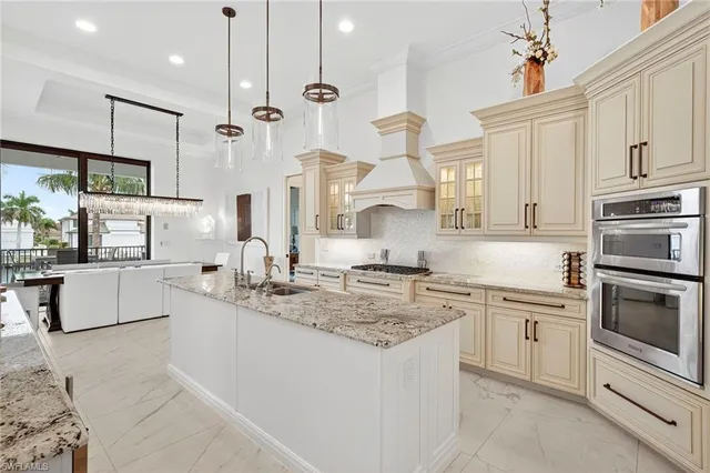 a kitchen with stainless steel appliances granite countertop a sink a stove and a refrigerator