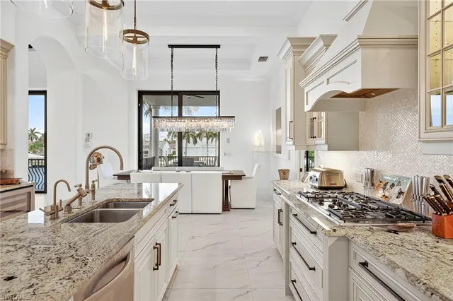 a kitchen with stainless steel appliances granite countertop a sink stove a refrigerator and cabinets