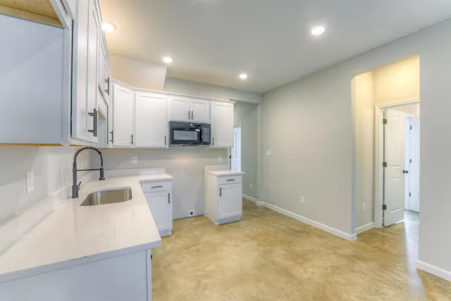 a kitchen with a sink a stove a refrigerator and cabinets