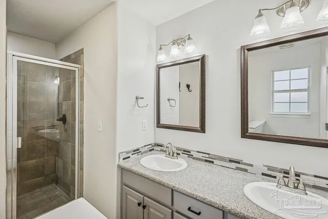 a bathroom with 2 sink and a mirror