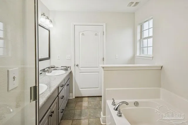 a bathroom with a tub sink and mirror