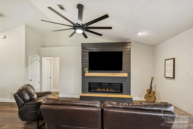 a living room with furniture a flat screen tv and a fireplace