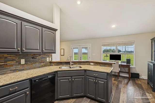 a kitchen with granite countertop a sink and a stove