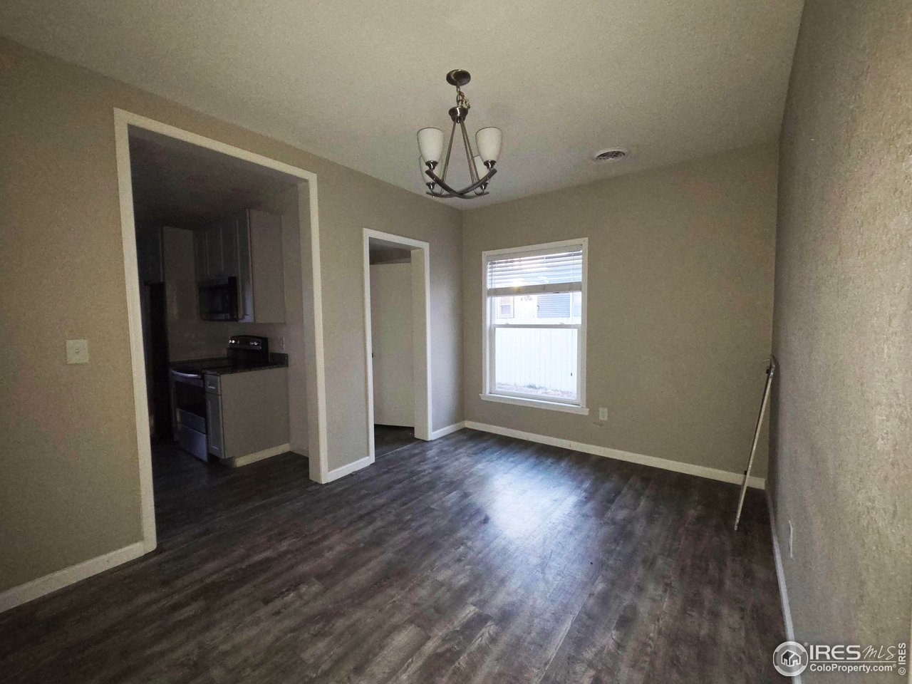 523 Chestnut Street Sterling, CO 80751 - Photo 3 of 13 wooden floor in an empty room with a window