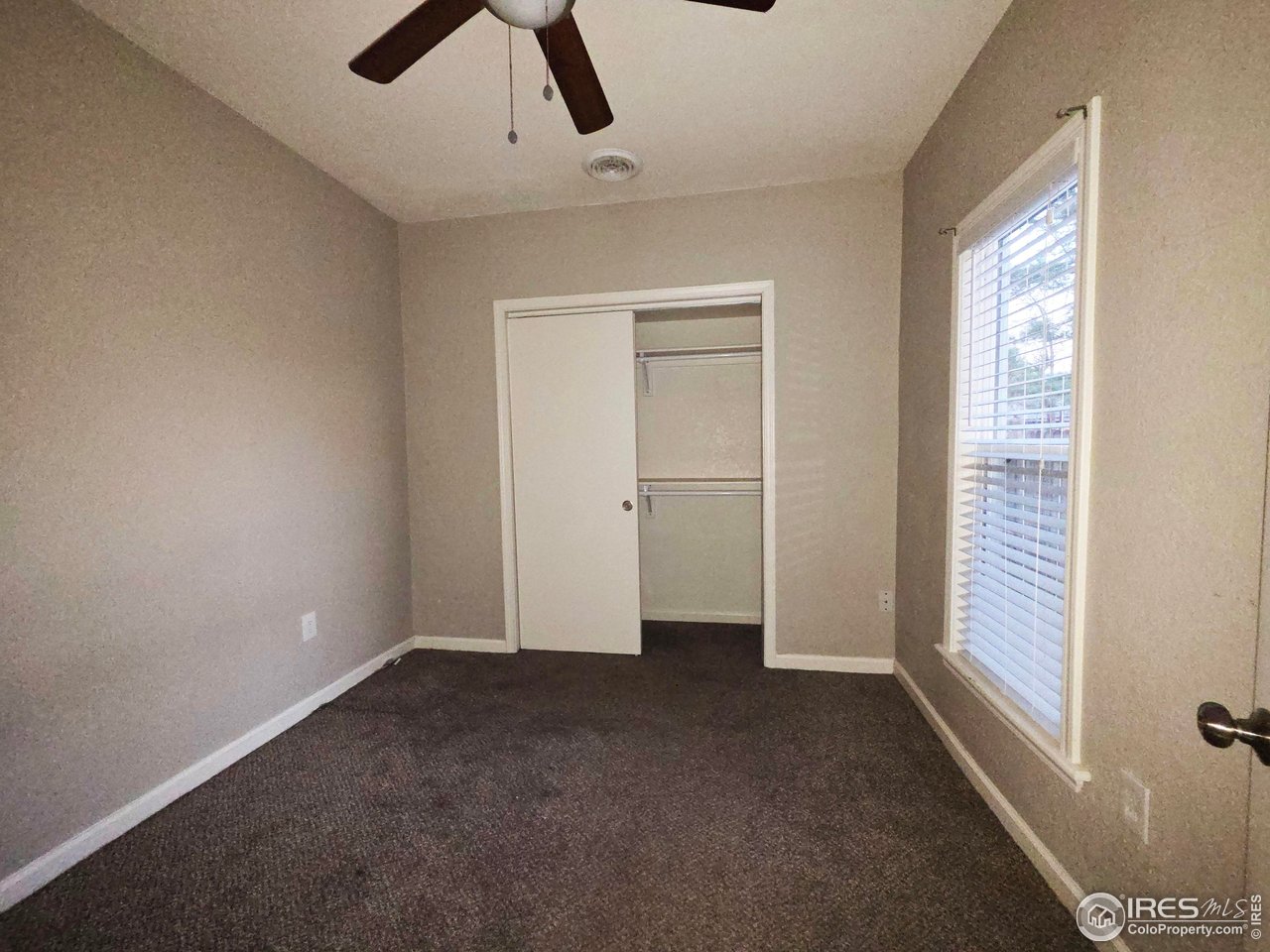 523 Chestnut Street Sterling, CO 80751 - Photo 6 of 13 an empty room with chandelier fan and windows