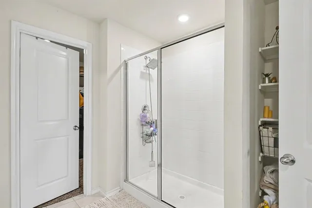 a bathroom with a shower and a glass door