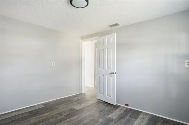 a view of a room with wooden floor and entryway