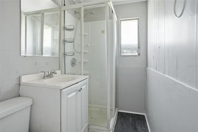 a bathroom with a sink a toilet and shower