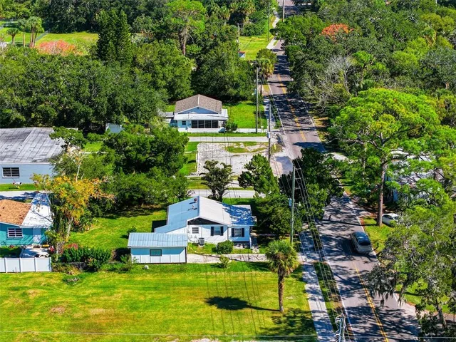 an aerial view of a house with a yard basket ball court and outdoor seating