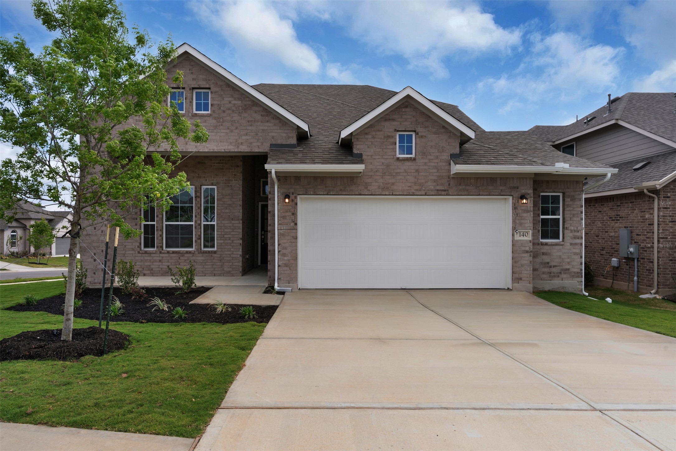 View of front of home featuring brick siding, driveway, roof with shingles, and an attached garage