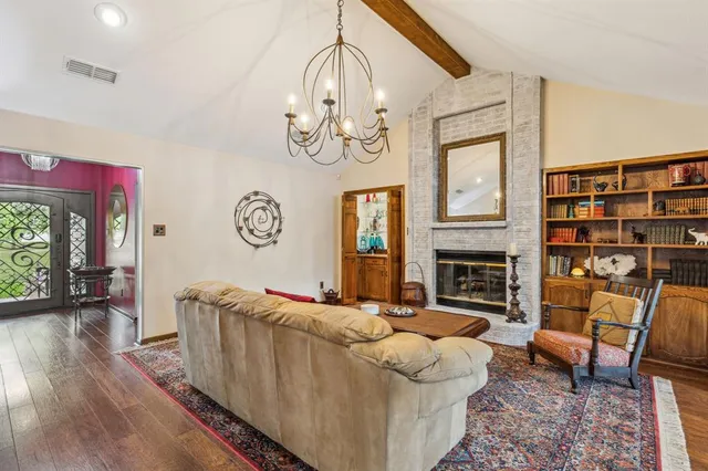 a living room with furniture a fireplace and a chandelier