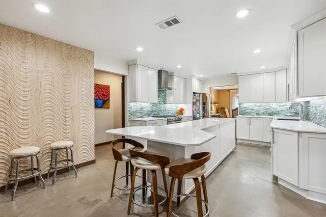 a large white kitchen with a table and chairs