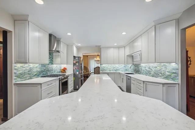 a kitchen with granite countertop a sink and white cabinets
